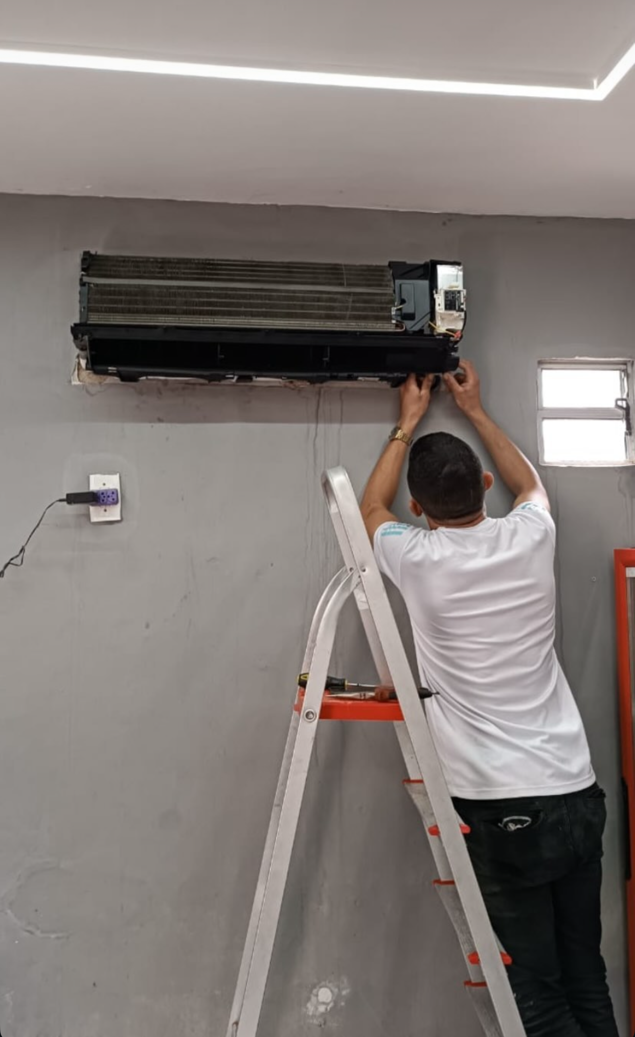 Técnico realizando instalação de ar-condicionado em residência