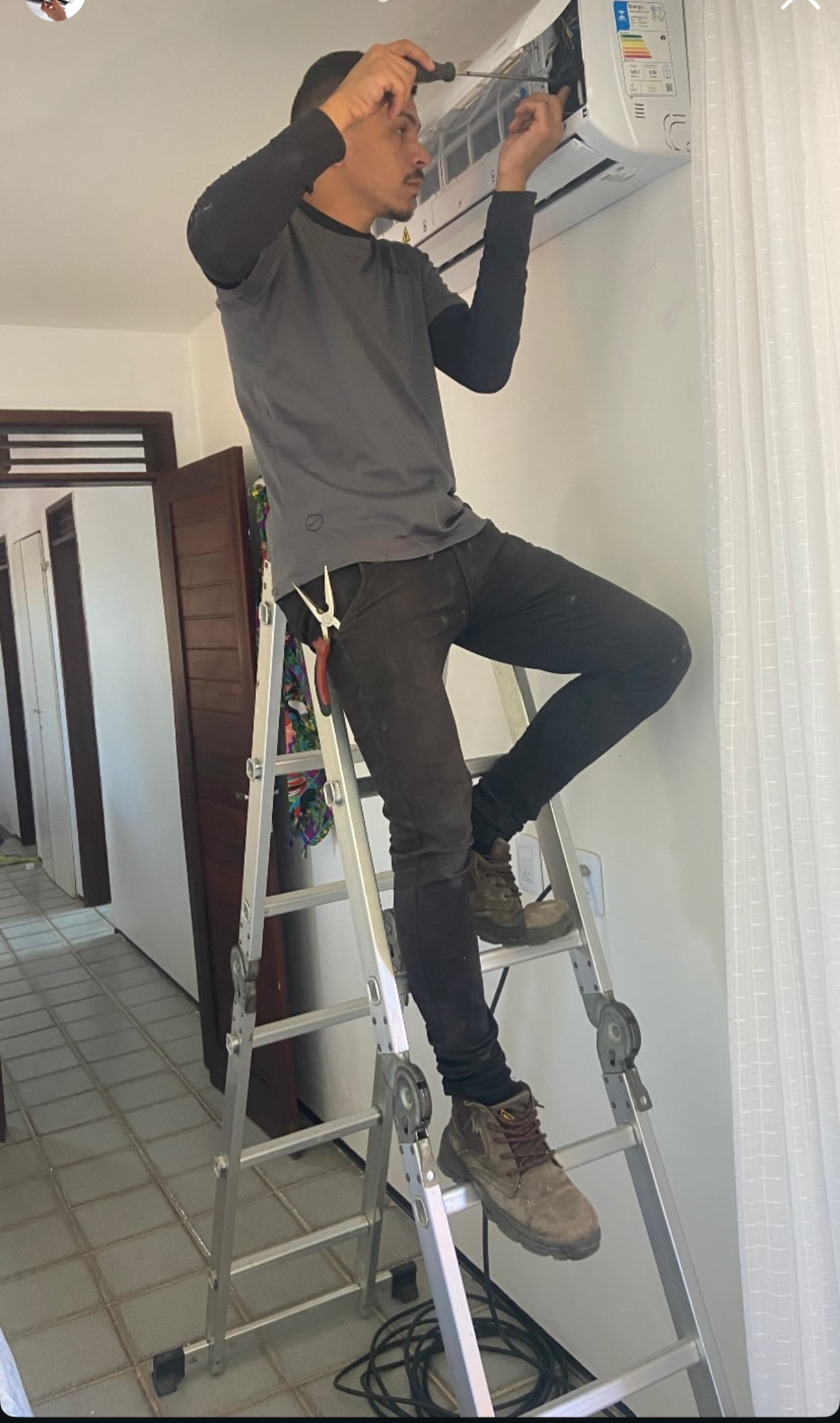Técnico IGOR realizando manutenção de ar-condicionado em residência